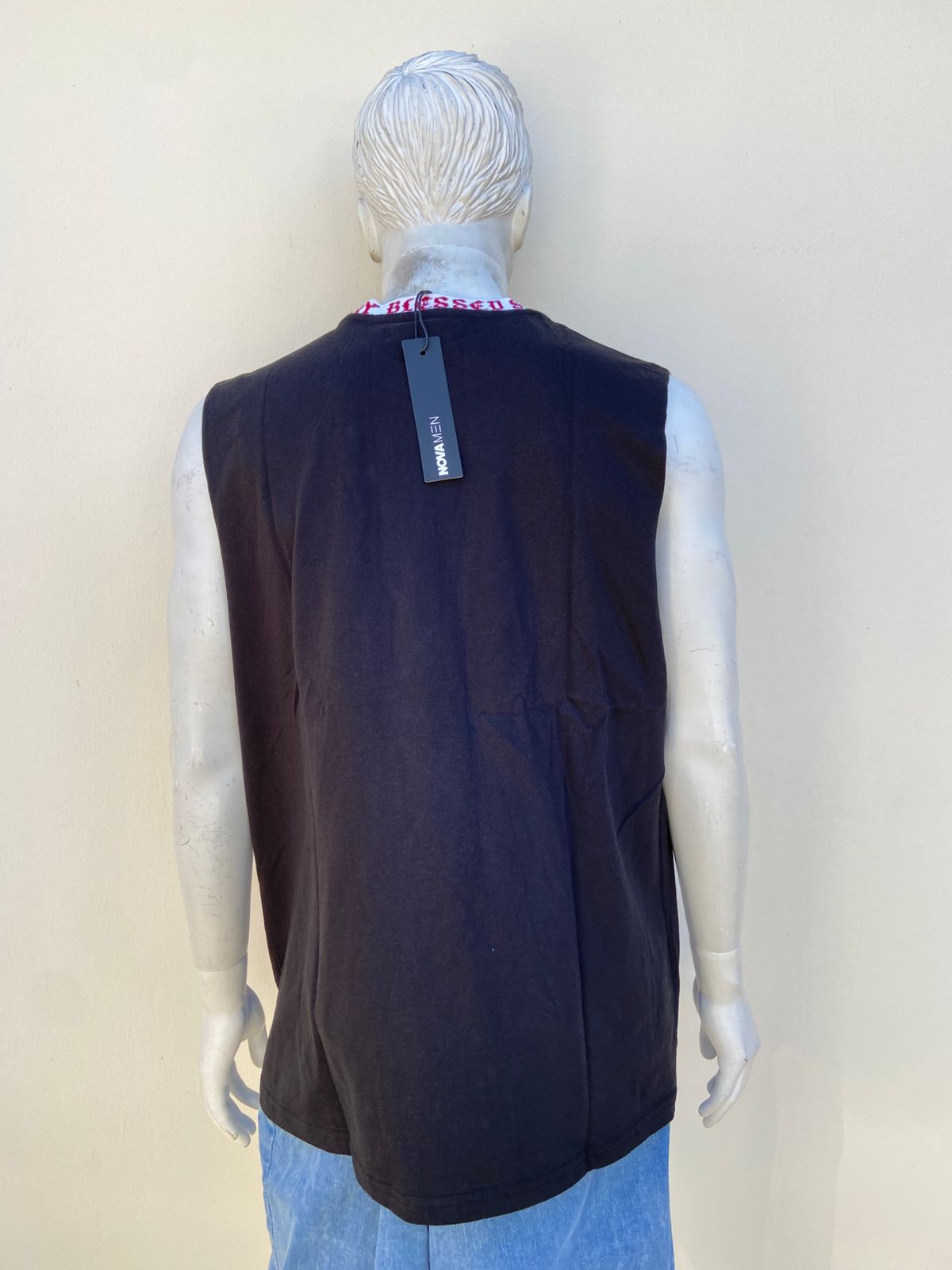 Franela, negra con estampado de cruces en la parte izquierda en color rojo.