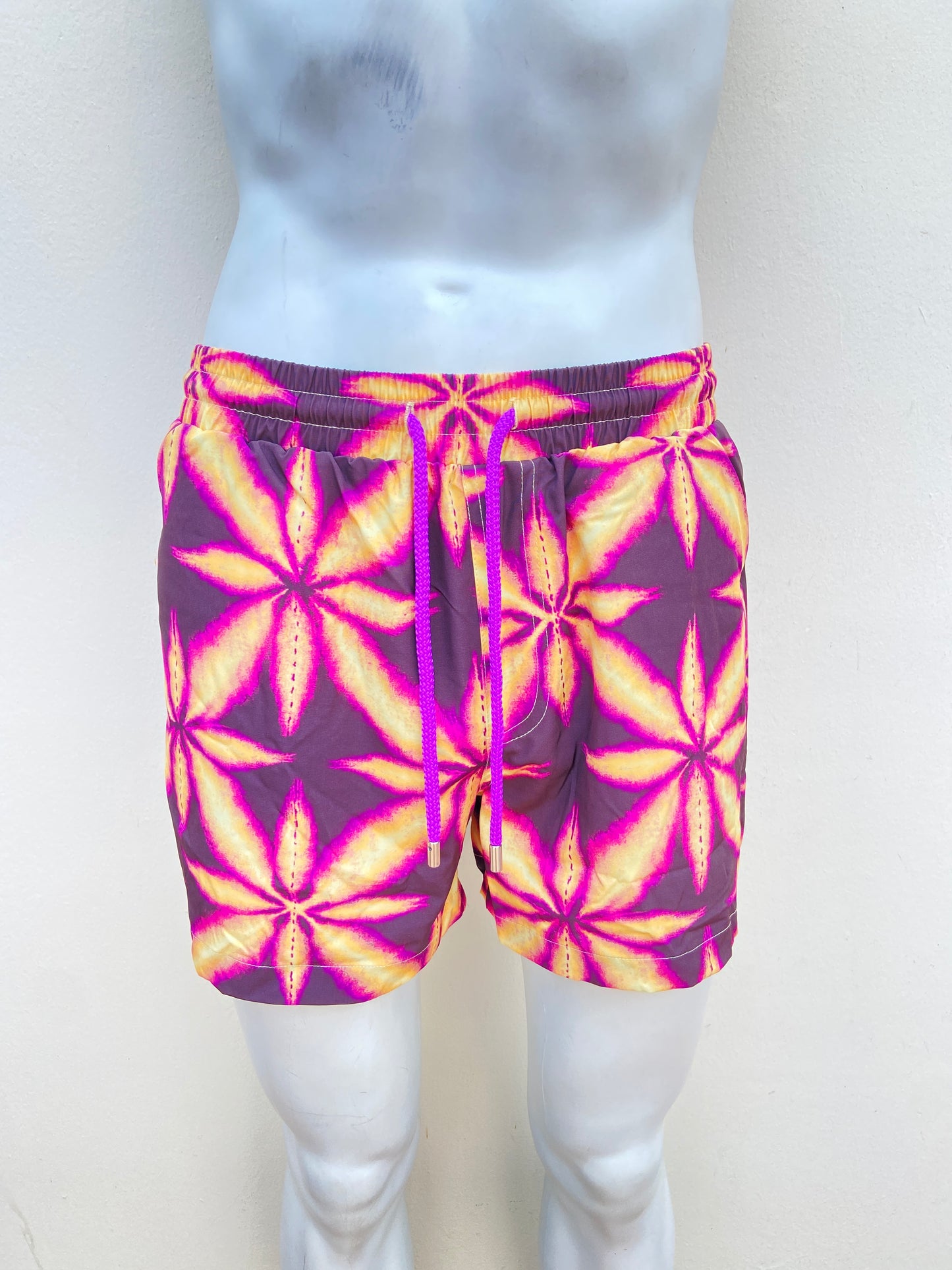 Bañador Baggy morado con estampado de una hoja amarilla.