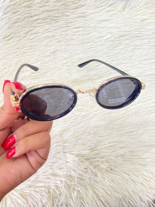 Lentes, negros con montura dorada ovalados, con protección UV 100% Polycarbonate.