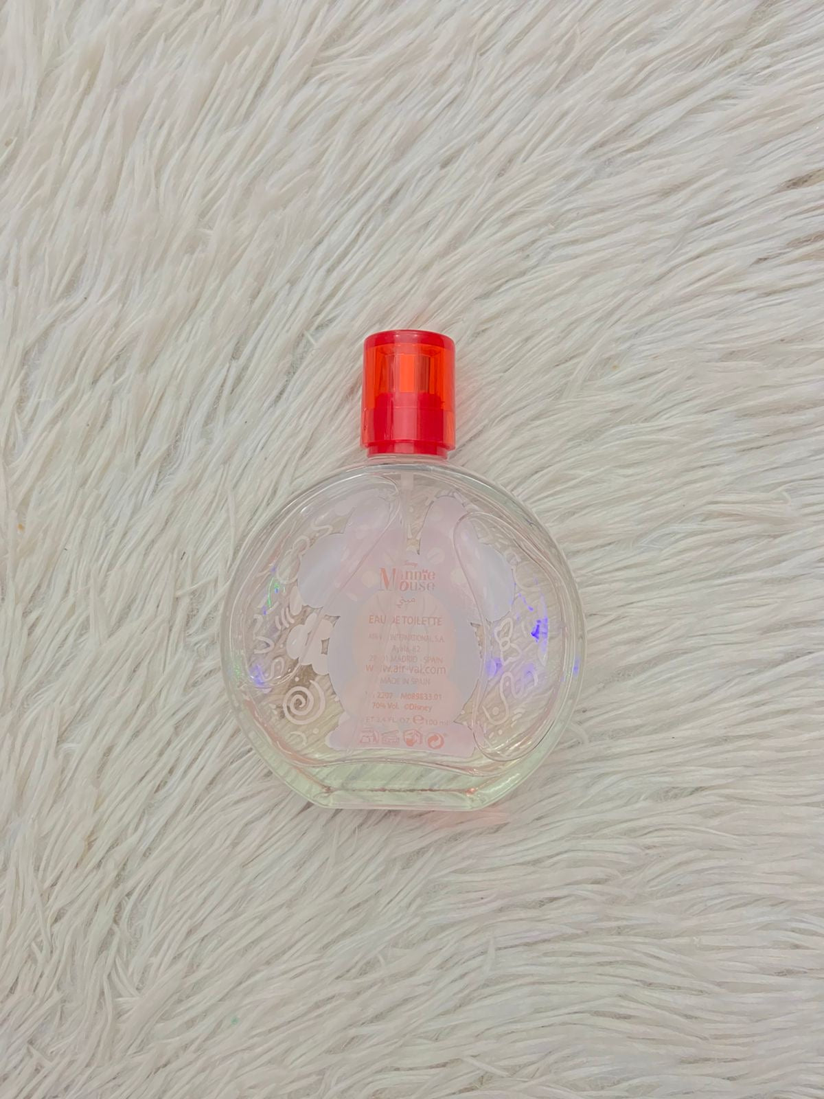 Perfume para niñas redondo con estampado de MINNIE MOUSE y fondo con dibujos decorativos en color blanco.