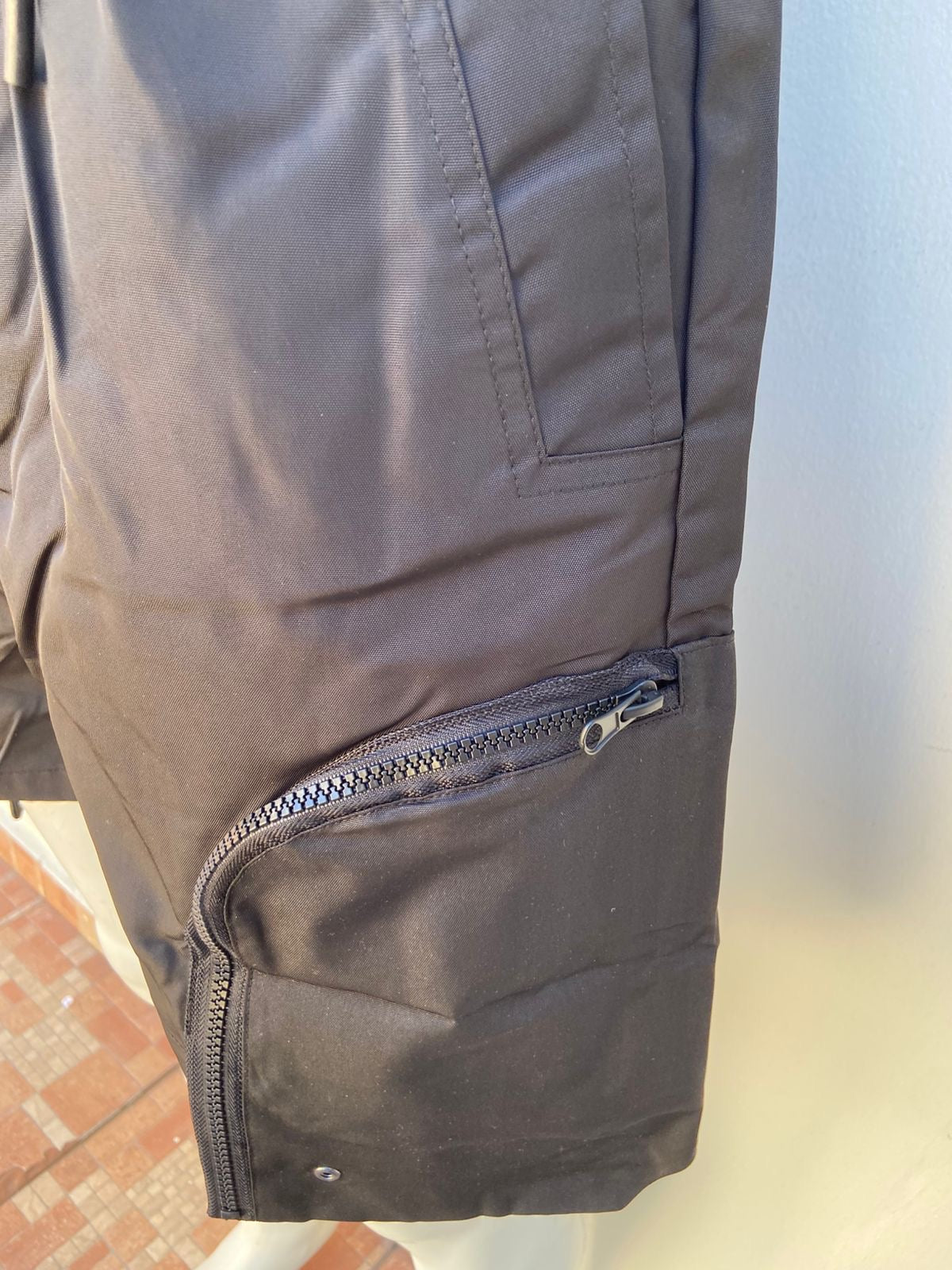 Bermuda, negra con bolsillo en los lados estilo cargo.