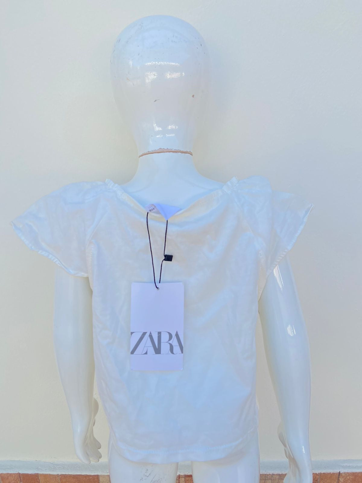 Blusa ZARA blanca con mangas con vuelo.