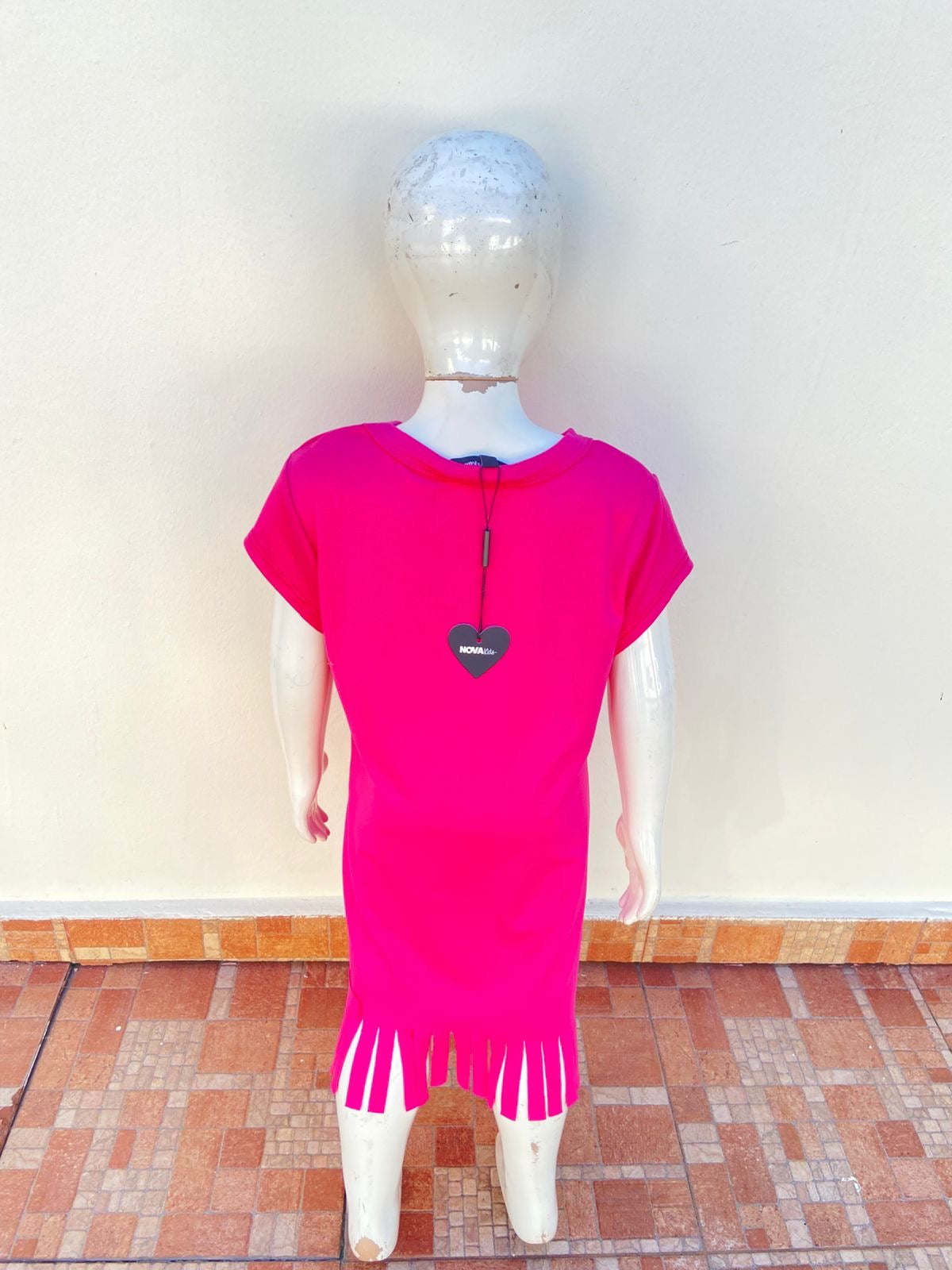 Vestido, rosado fucsia con letras SASSY ( atrevida )en negro y tiras en la parte inferior.
