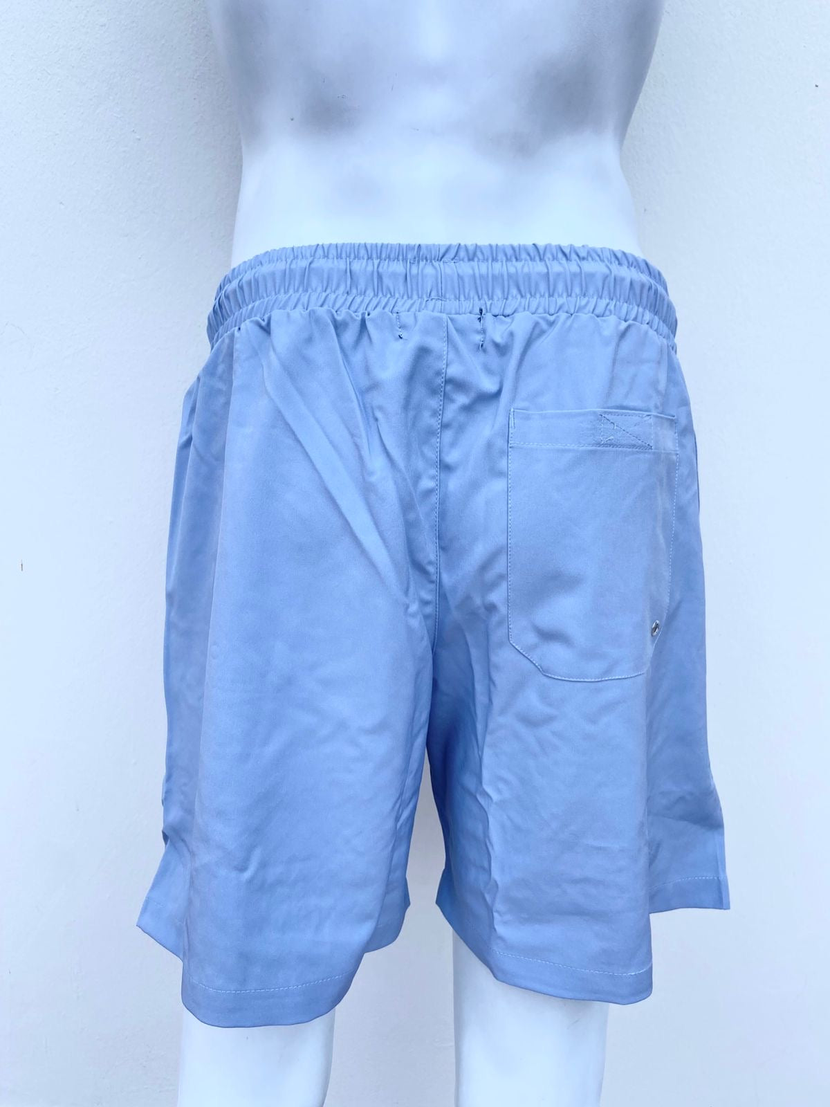 Bañador Baggy azul con detalles abajo en color blanco.