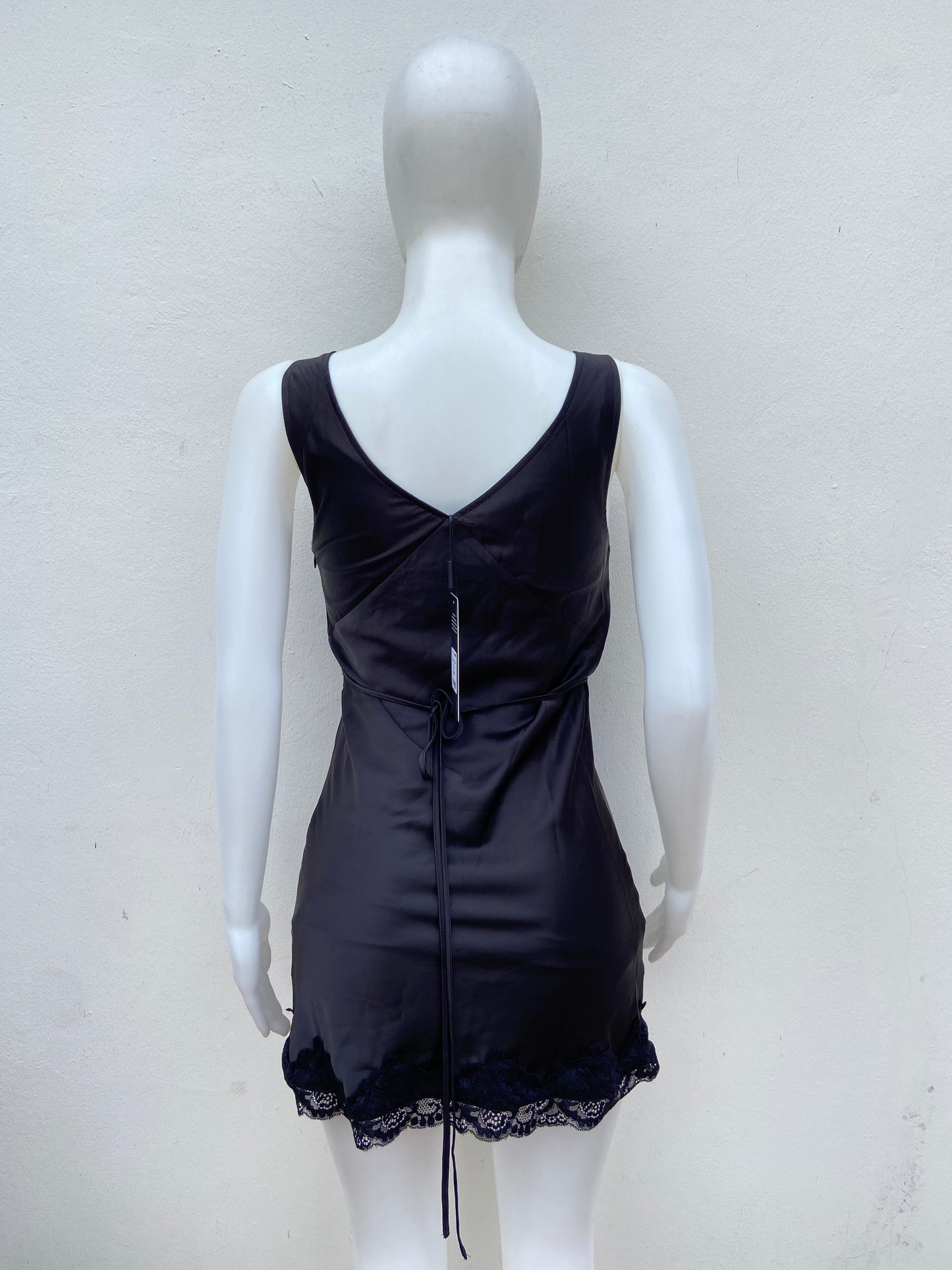 Vestido negro, escote en V y encaje en la parte inferior.