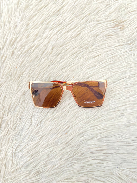 Lentes, diseñados con protección UV 100-400 para proteger tu visión. Marrón con montura en dorado y micas marrones.