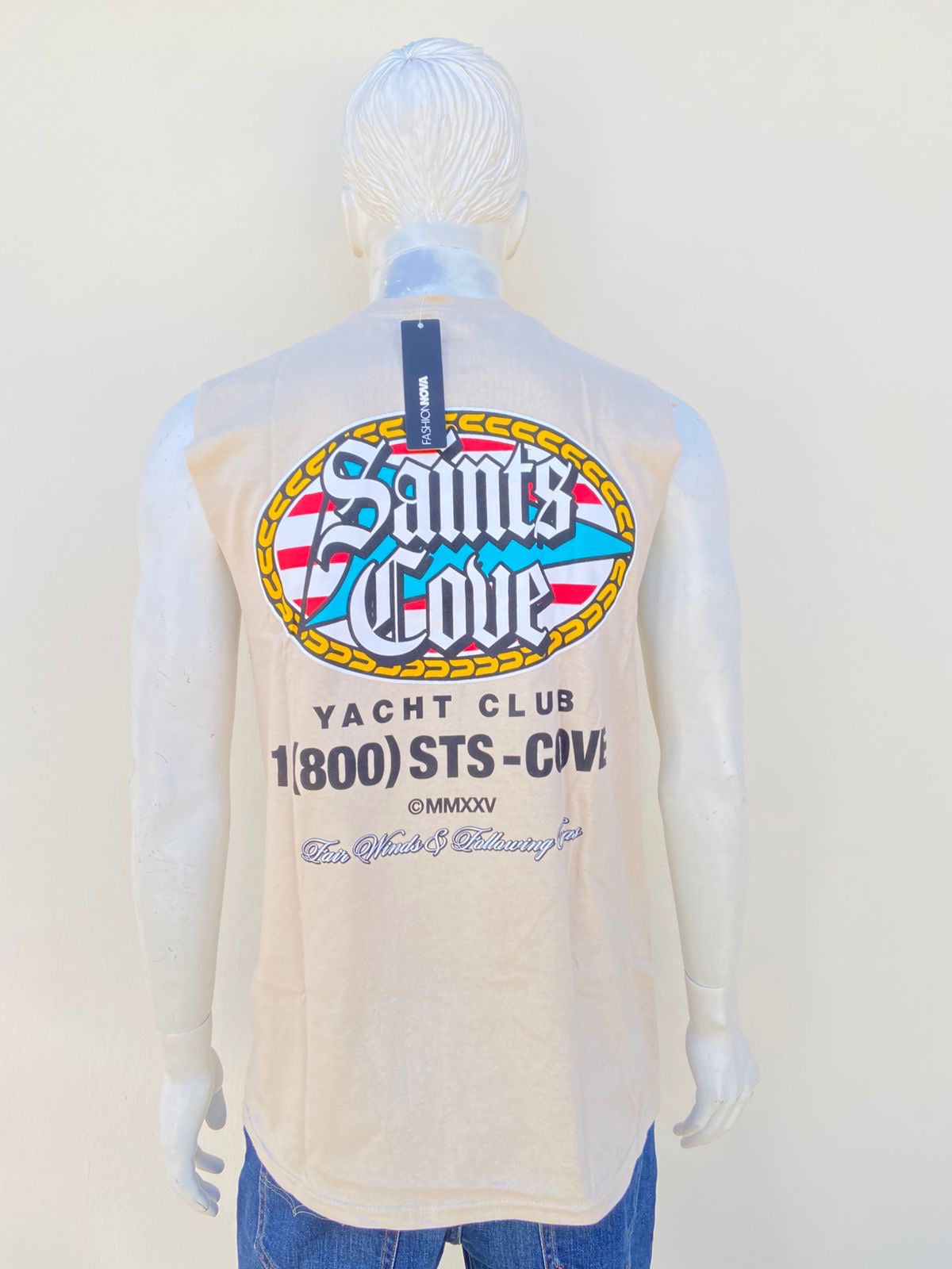 Franela en color crema (beige) con estampado atras, letras y numeros en color negro. saints cove yacht club 1(800) sts-cove.