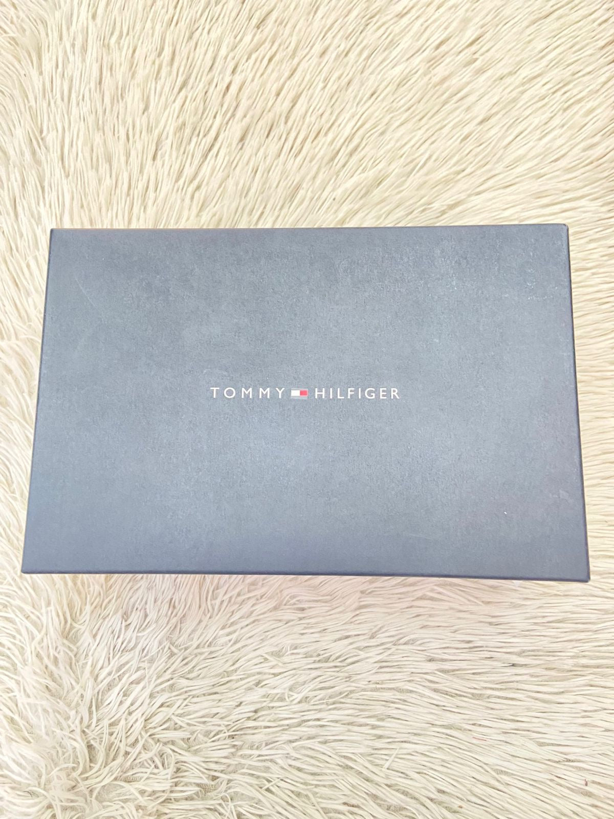 Tenis Tommy Hilfiger Original en color blanco con bandera de la en los lados y letra Tommy en el medio