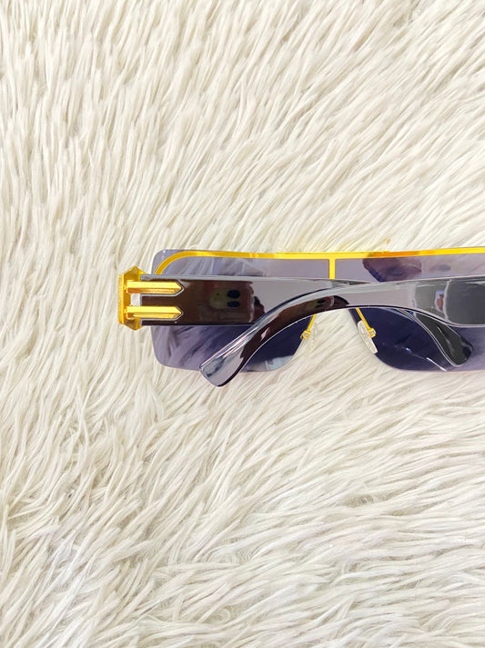 Lentes con protección UV 100-400 para proteger tu visión. En color negro con detalles dorados en los lados.