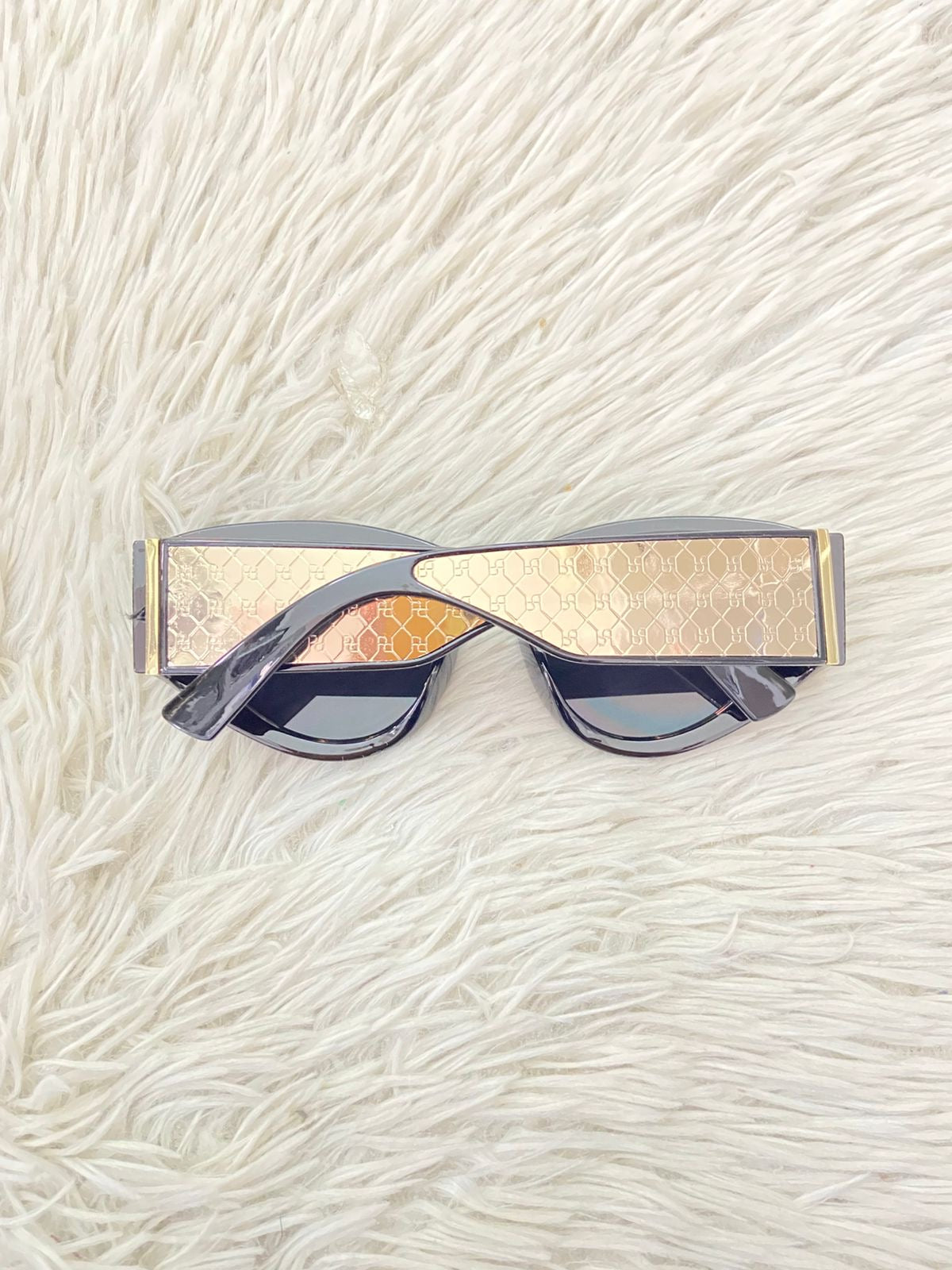 Lentes negros con detalles en color dorados y micas oscuras