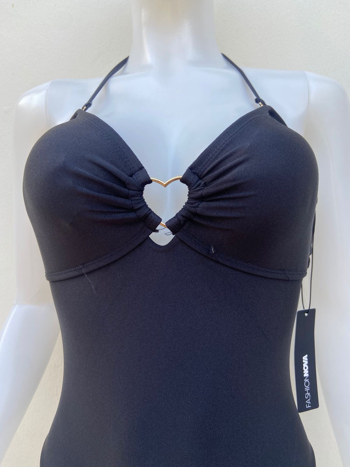 Biquini, negro liso con placa en medio en forma de corazón y lazos ajustables.