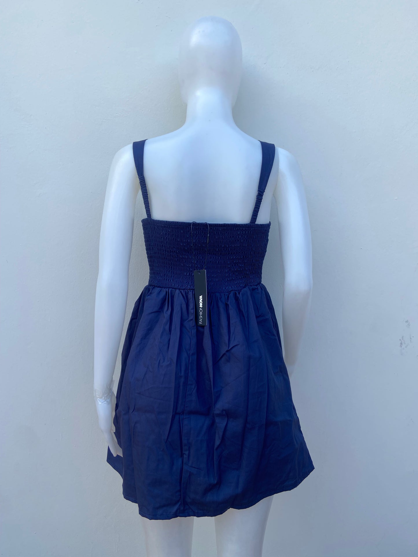 Vestido, algodón orgánico en azul marino ( NAVY) con flor rosada en frente.