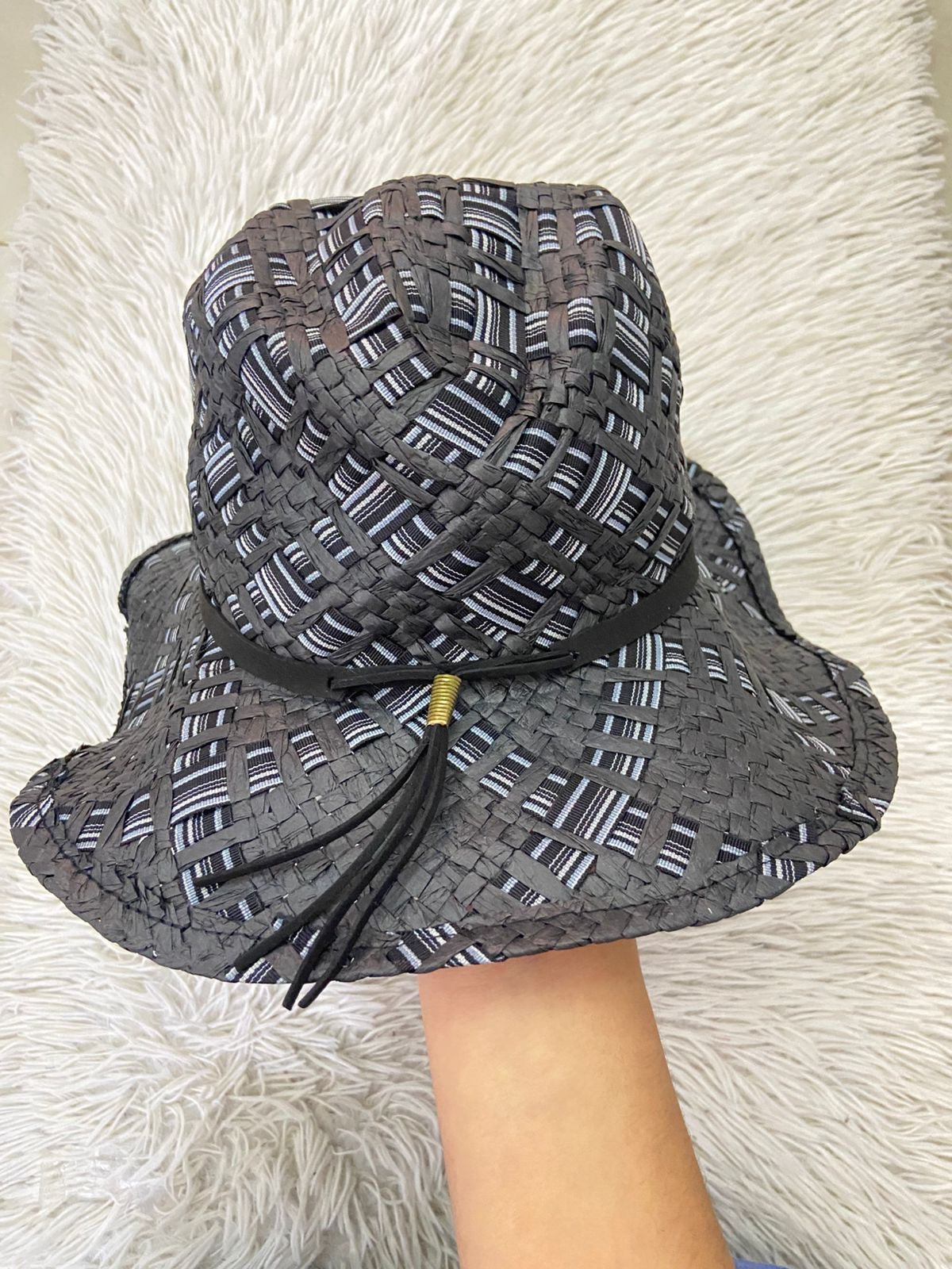 Gorro en color negro tejido con tejido de hilo y tela cruzada en color negra y tonos azules y lazo caido al frente