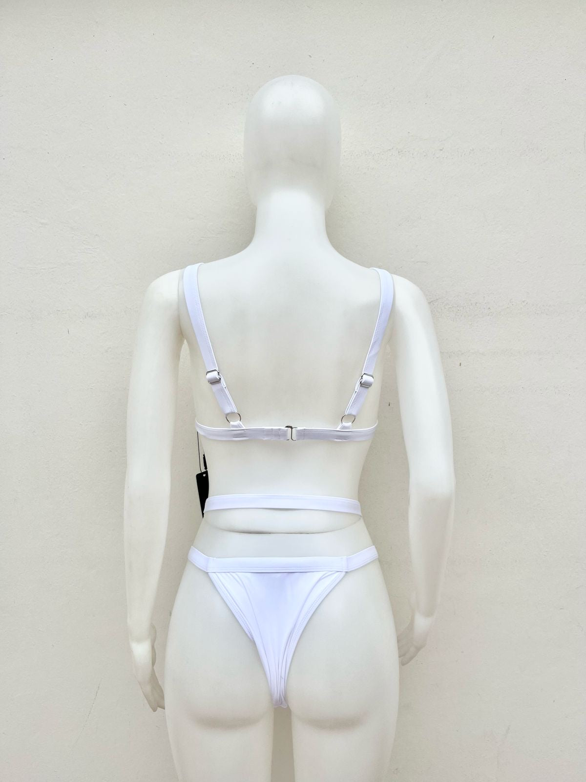 Biquini, de dos piezas blanco con lazos en la cintura y lazos ajustables.