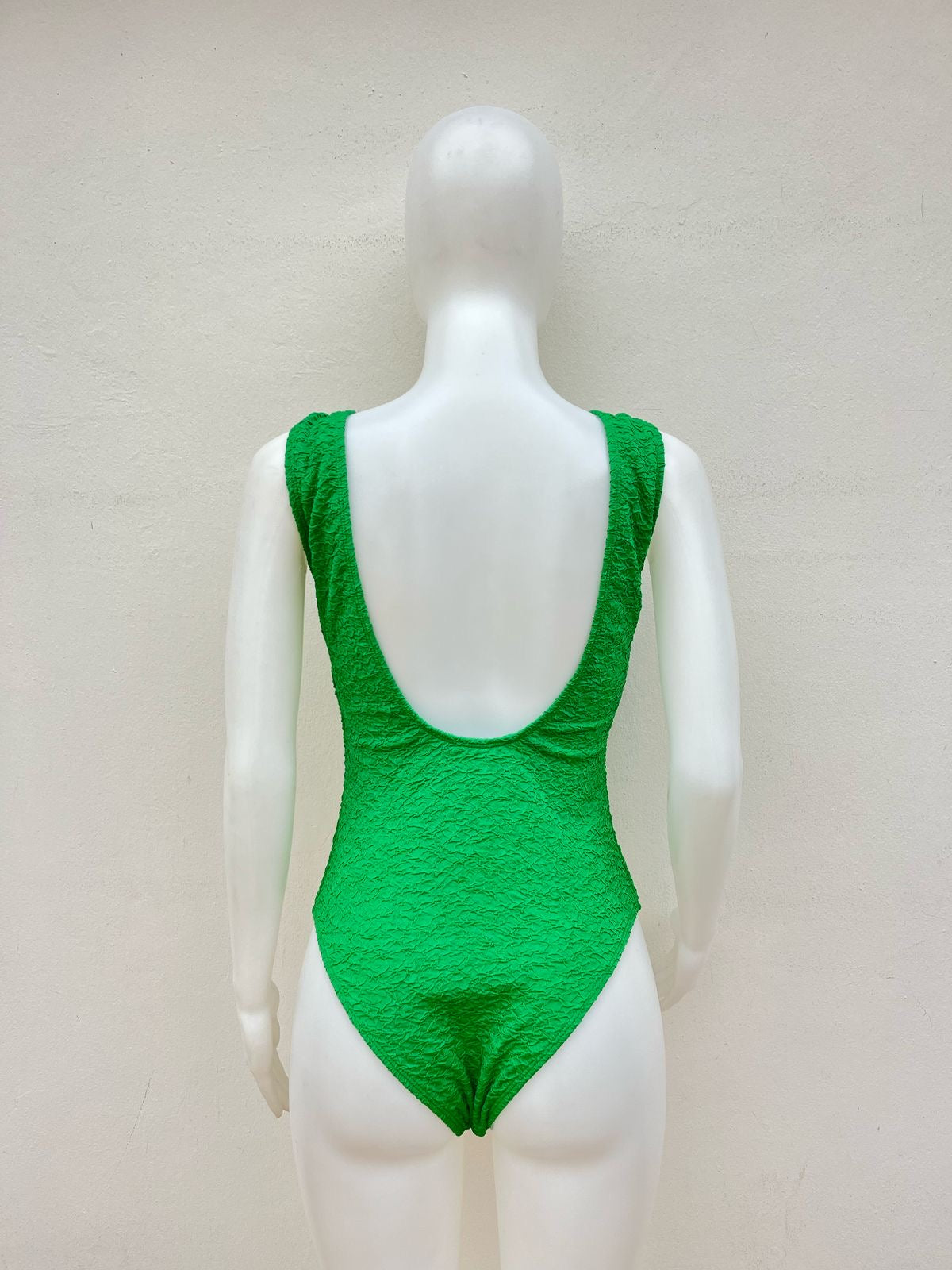 Biquini, de una pieza verde con escote en la espalda y de talles de aros en animal print