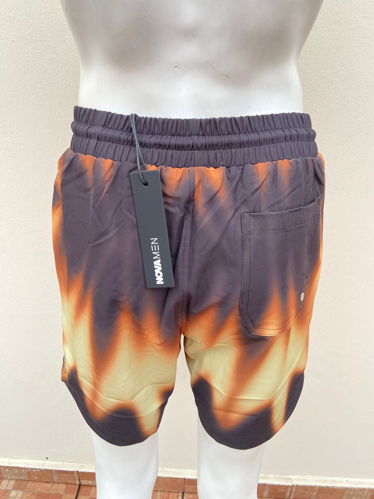 Bañador, marrón con amarillo y naranja más lazos ajustables.