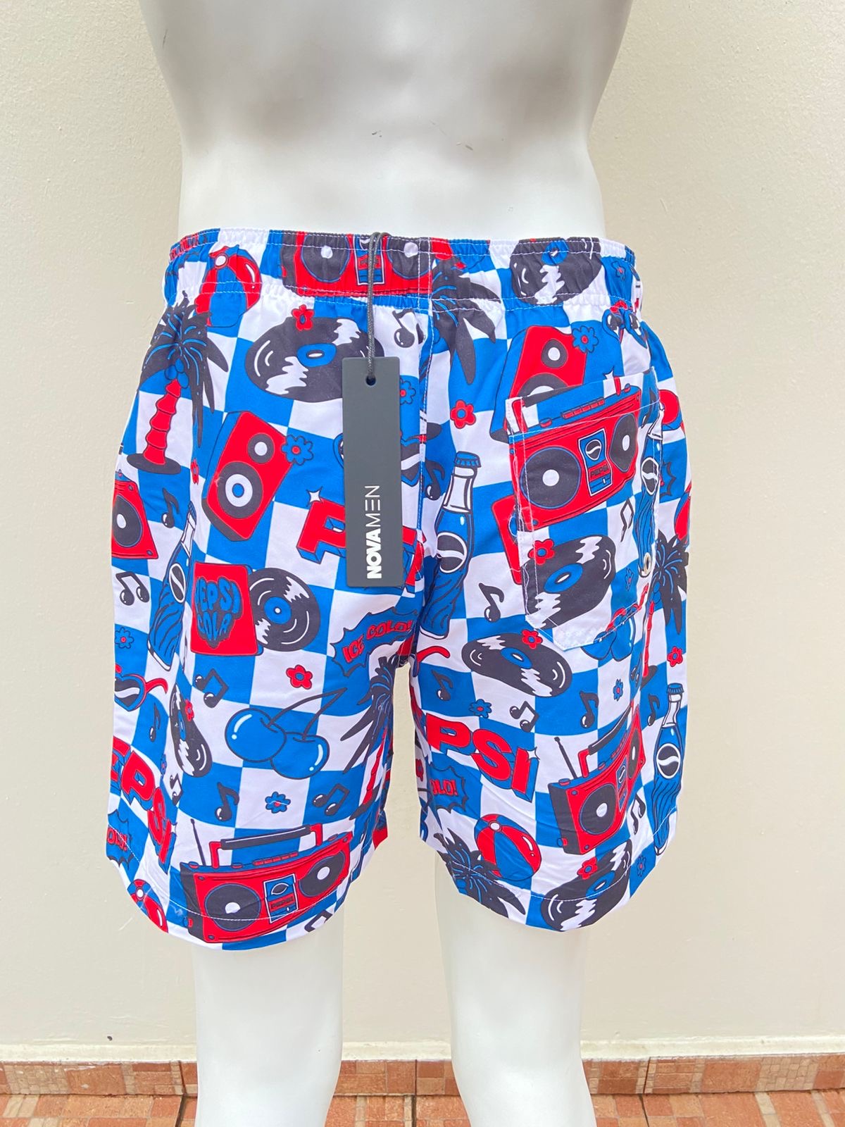 Bañador, azul con estampado de discos, palmeras y flores en color blanco y rojo.