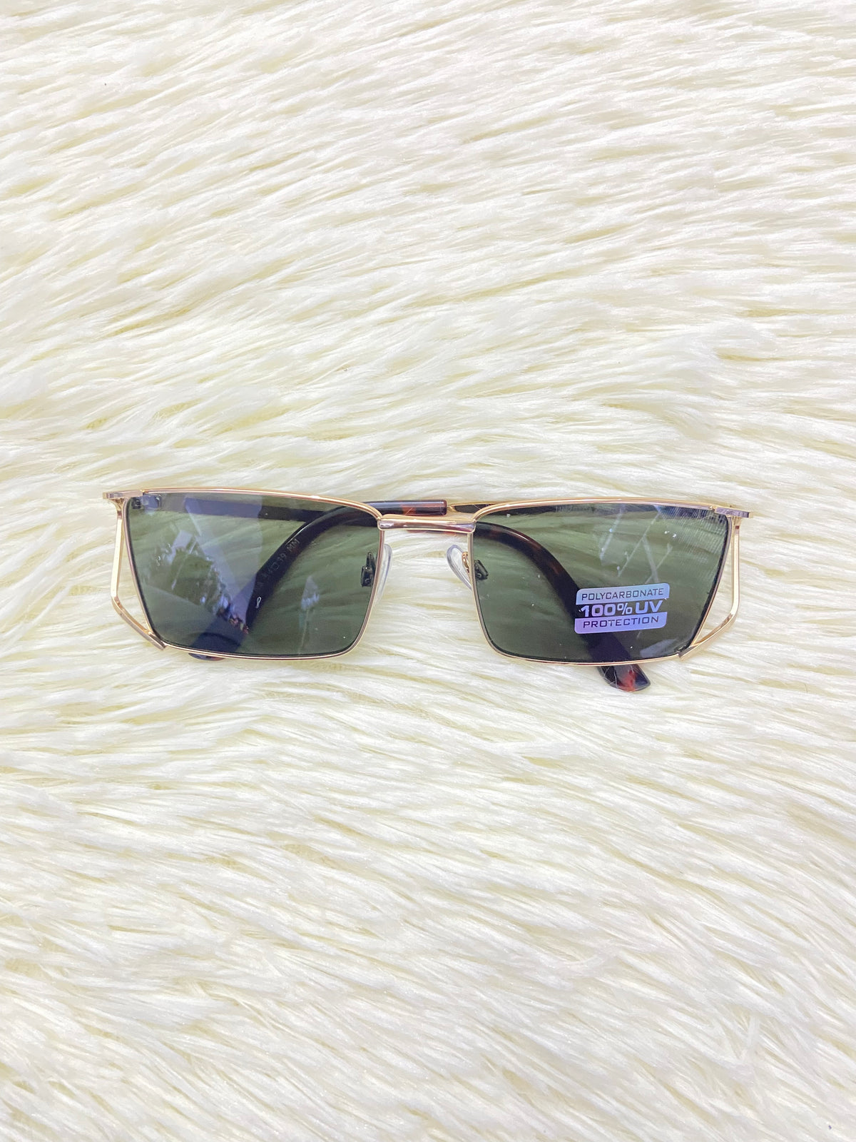 Lentes, con montura dorada y micas en color verde oscuro, con protección UV 100%.