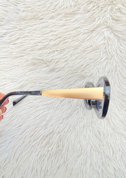 Lentes, diseñados con protección UV 100-400 para proteger tu visión. Negro con montura en dorado y micas en forma de óvalo.