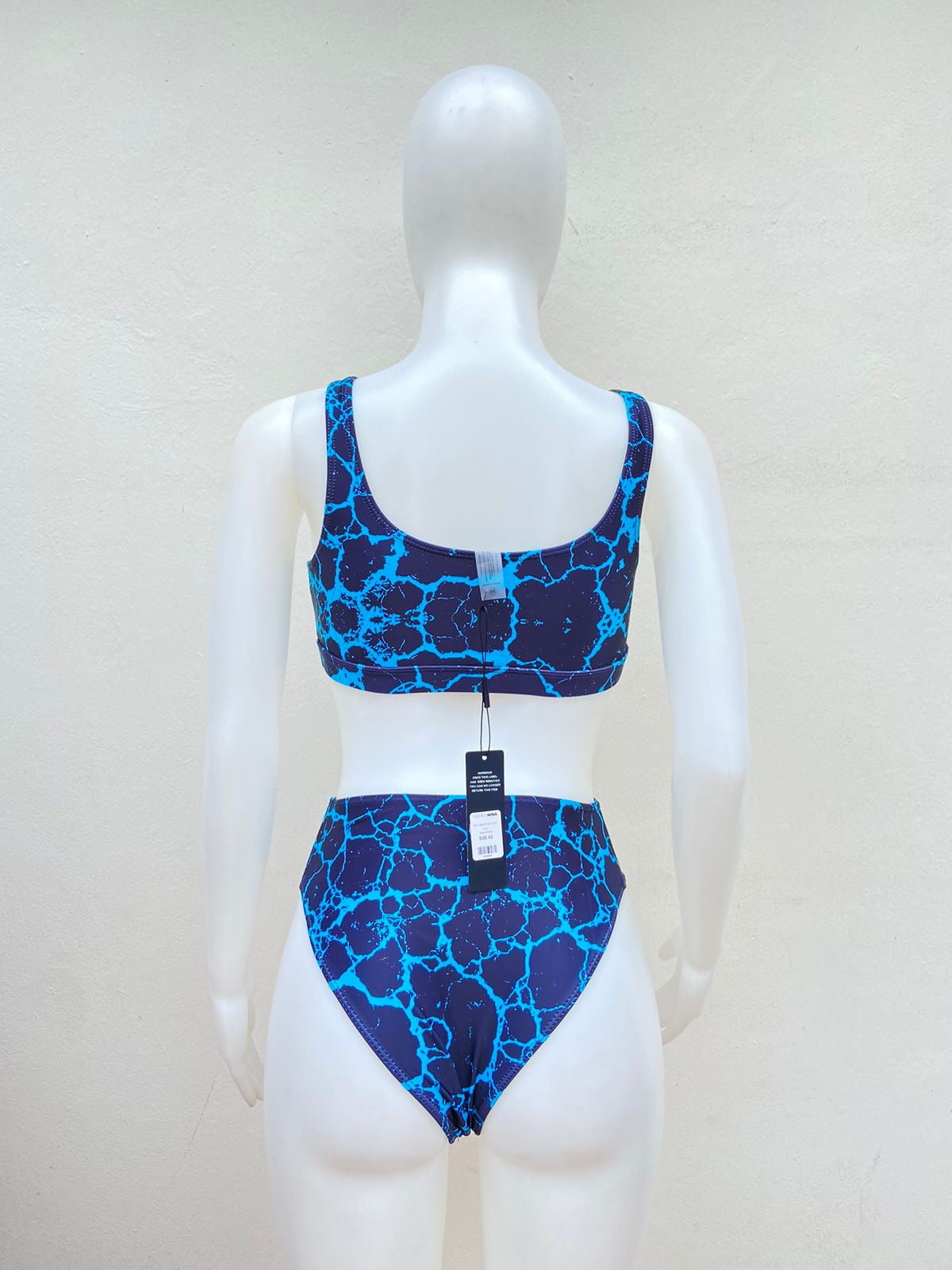 Biquini,de dos piezas negro con estampado de grietas en color azules con letra al frente FIERCE y panti alto