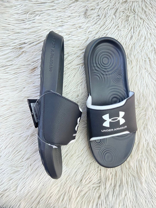Sandalias UNDER ARMOUR Original, negra con nombre, logotipo de la marca y detalle en color blanco al frente.