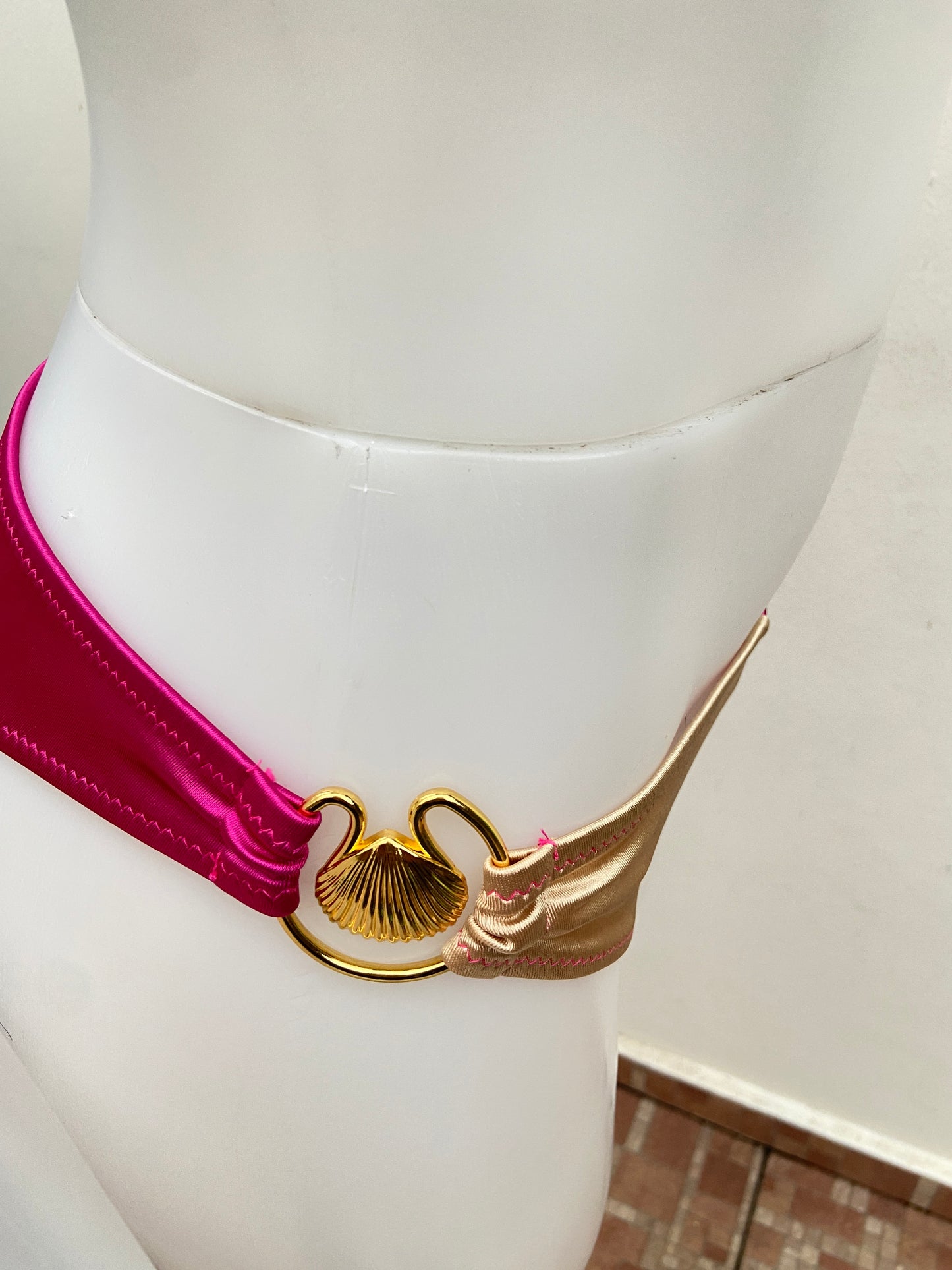 Biquini, de dos piezas rosado fucsia con dorado y detalles dorado en frente y de lado .