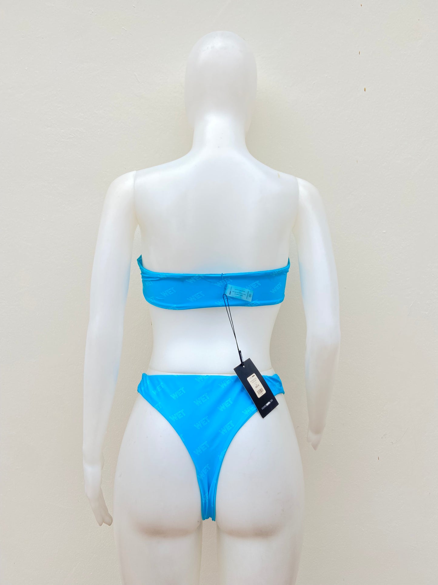 Biquini, azul claro con letras WET en blanco, strapless, 2 piezas.