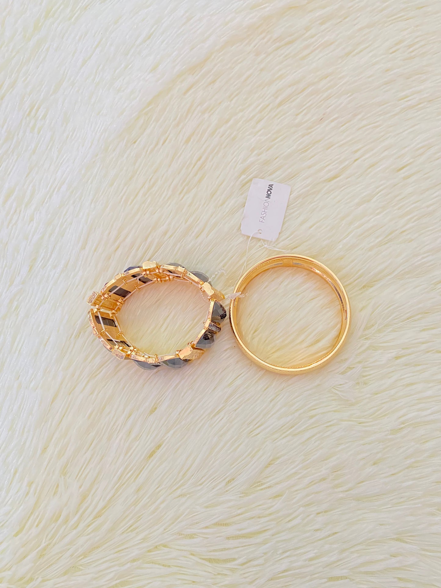 Set de pulseras una en color dorado con detalles plateados y otra con Piedras grandes negras y doradas.