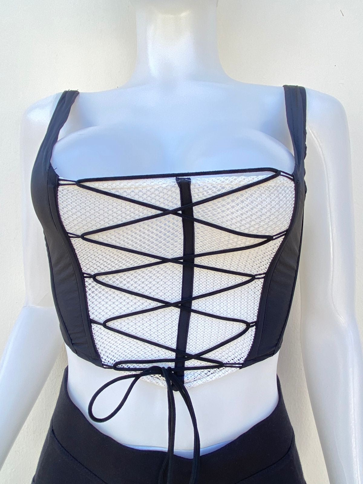 Top, negro con blanco estilo corset y lazos ajustables.