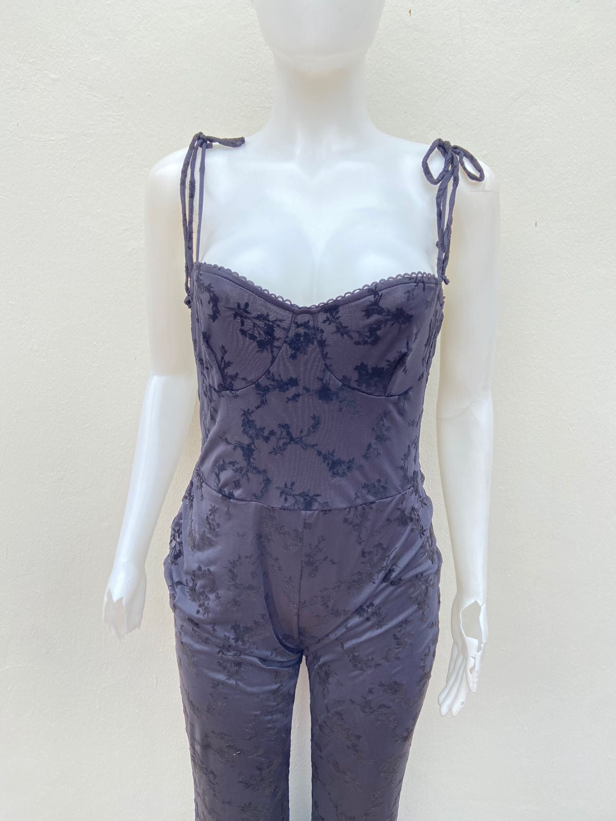 Enterizo, negro con estampado de flores en terciopelo y lazos ajustables.