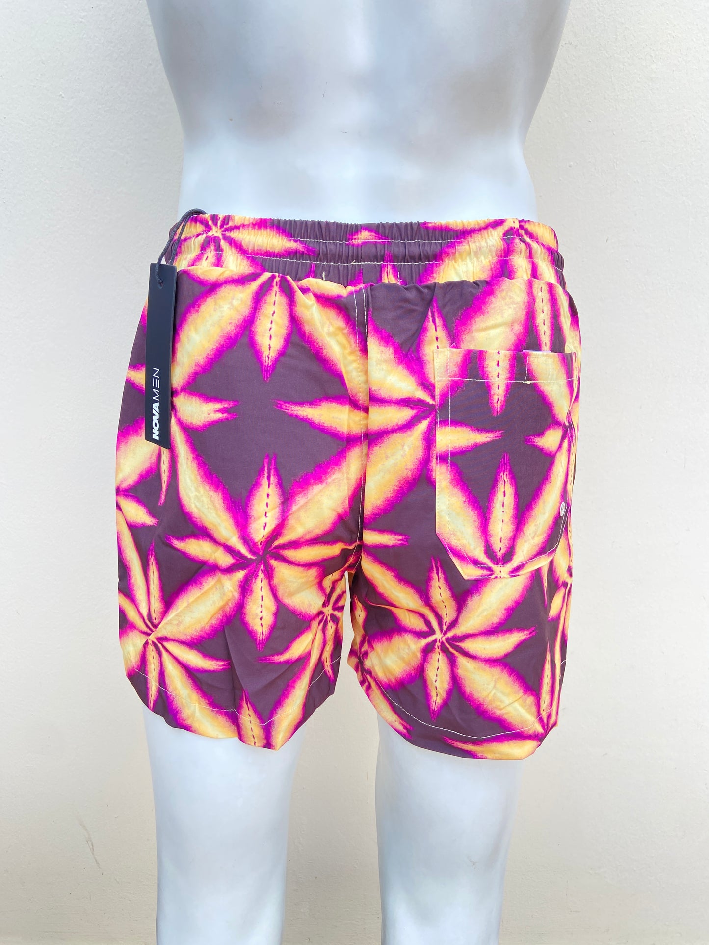 Bañador Baggy Nova Men original morado con estampado de una hoja amarilla.