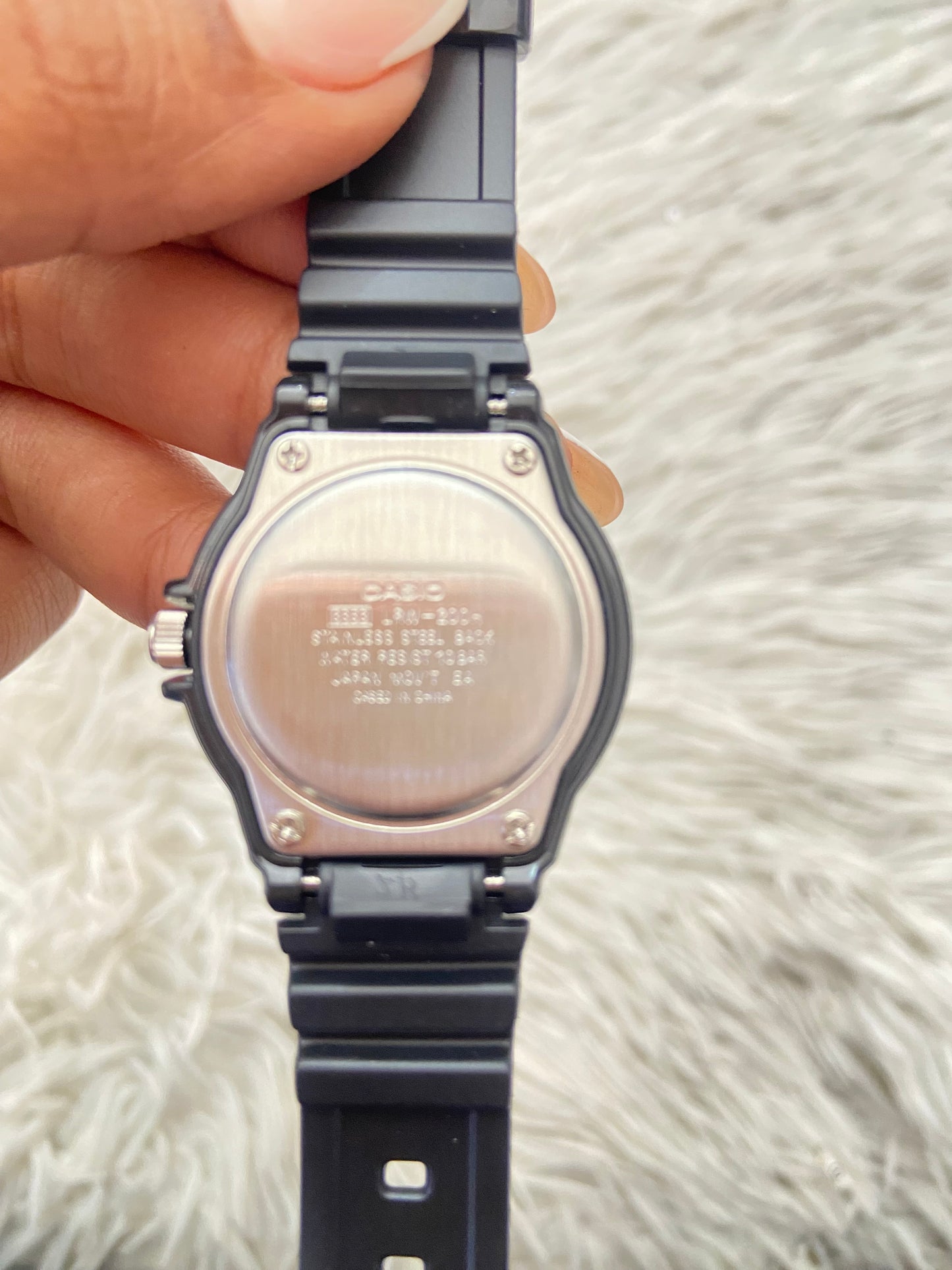 Reloj Casio original negra con fondo en color blanco y verde.