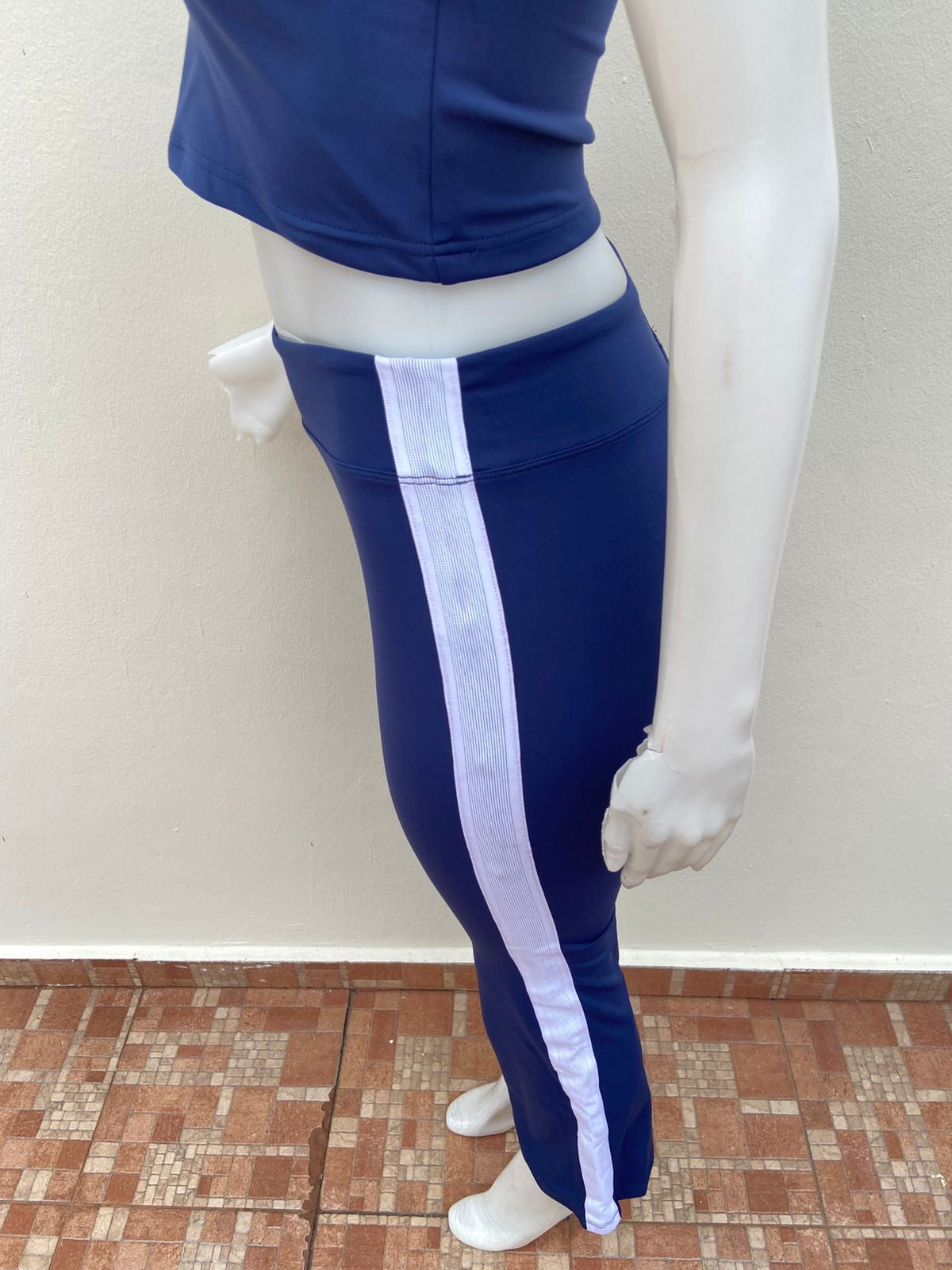 Conjunto top y legging en color azul marino con lineas blancas en los lados, top sin mangas y cuello blanco.