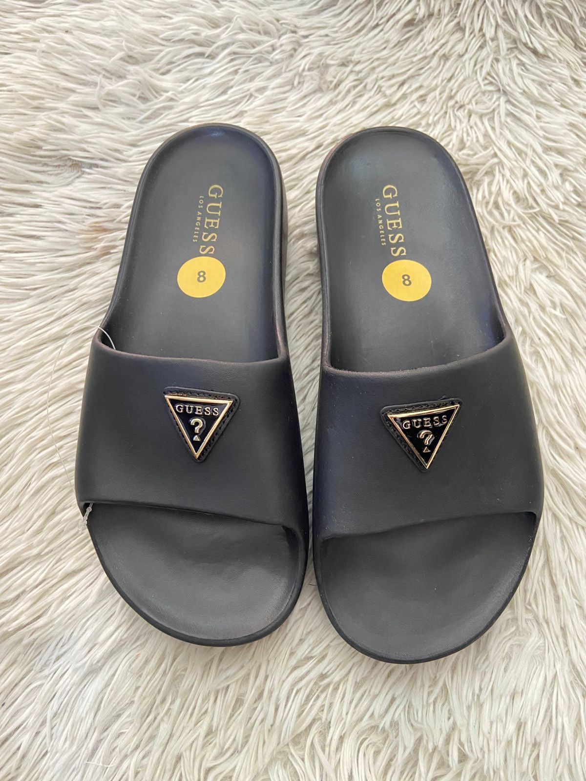 Sandalias GUESS original, negra con plataformas y placa GUESS en frente en color dorado y negro.