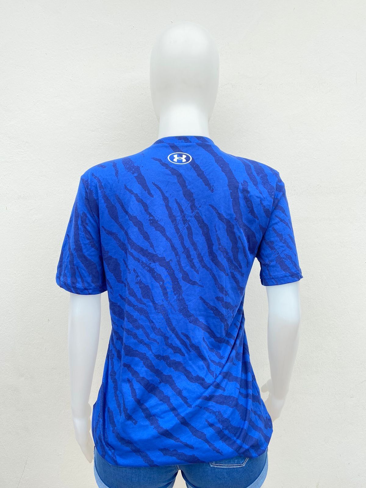 T-shirt Under Armour original azul con estampado de animal print y logotipo de un toro en blanco.
