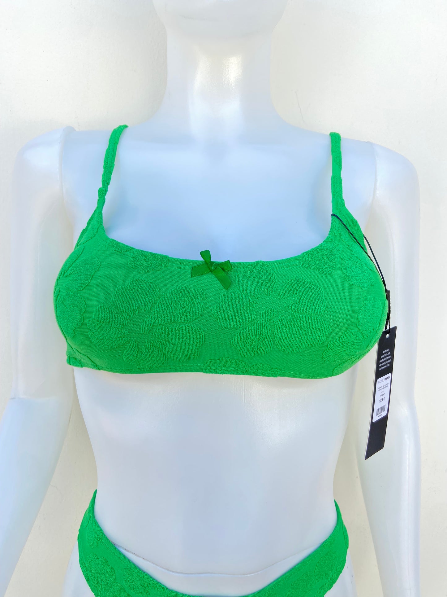 Biquini, verde con estampado de flores del mismo color y lazo enfrente.