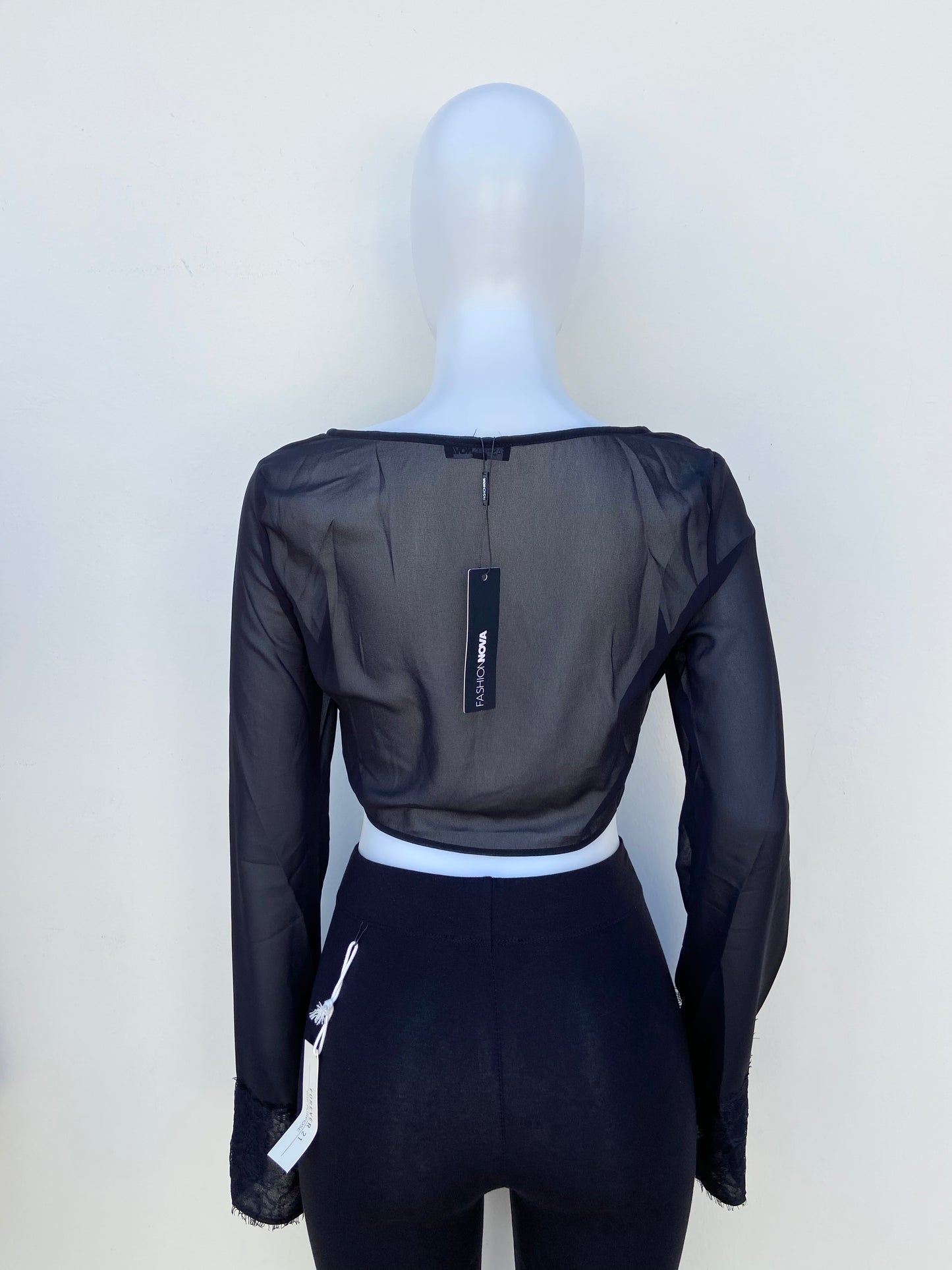 Top Fashion Nova original negro transparente y abierto en la parte delantera y encaje en las mangas.