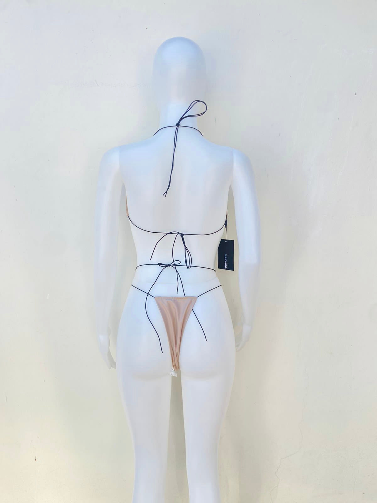 Biquini, de dos piezas color crema con lazos negros. THE HILLS