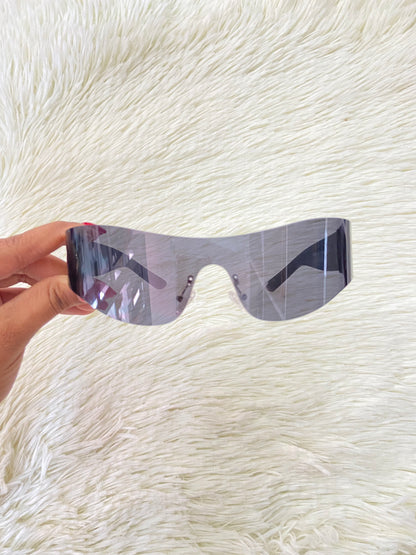 Lentes, negros curvos con detalles plateados en la montura.