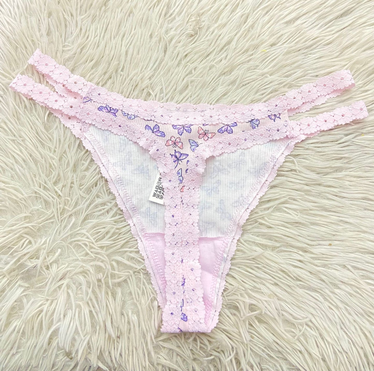 Panti PINK original rosado en encaje con estampado de mariposas moradas.