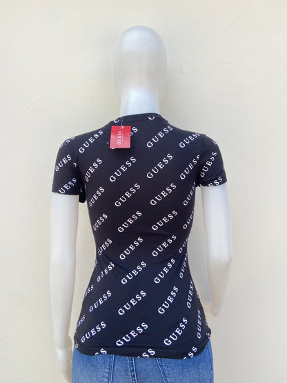 T-shirt GUESS original, negro con estampado de otras GUESS en blanco y triángulo en dorado con su logo.