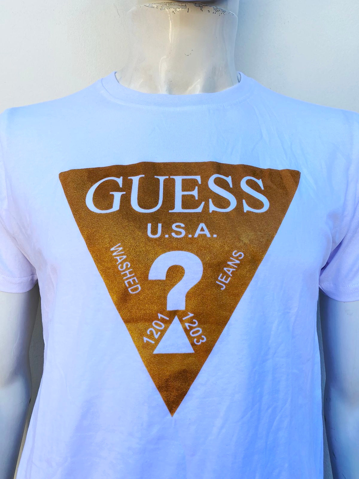T-shirt Guess original blanco con logotipo Gues en dorado, en forma de triangulo y signo de ?.