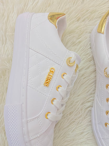 Tenis GUESS original blanco con detalles en color dorado y placa GUESS en dorado.