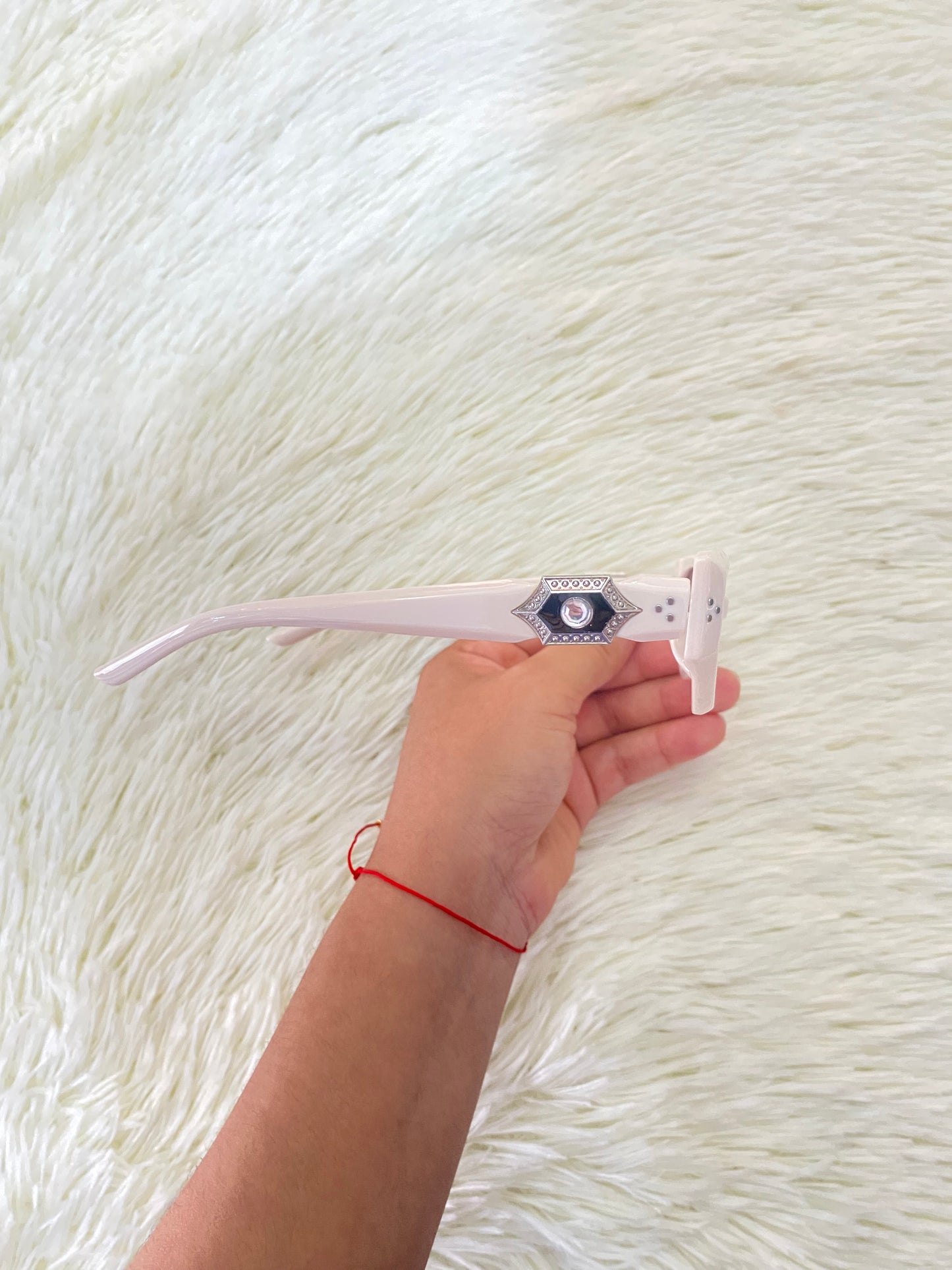 Lentes color blanco/hueso con micas oscuras con detalle plateado con negro atrás.