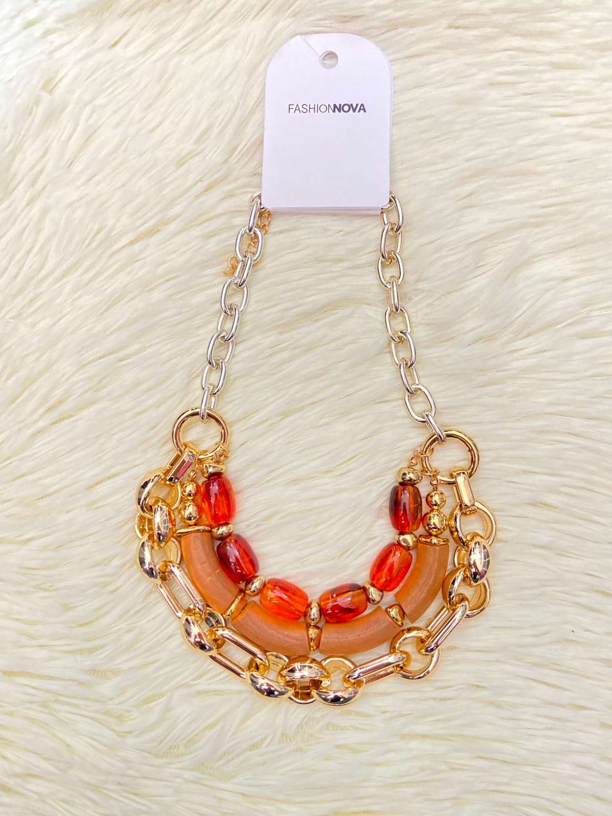 Cadena, dorada con piedras en color rojo y naranja.
