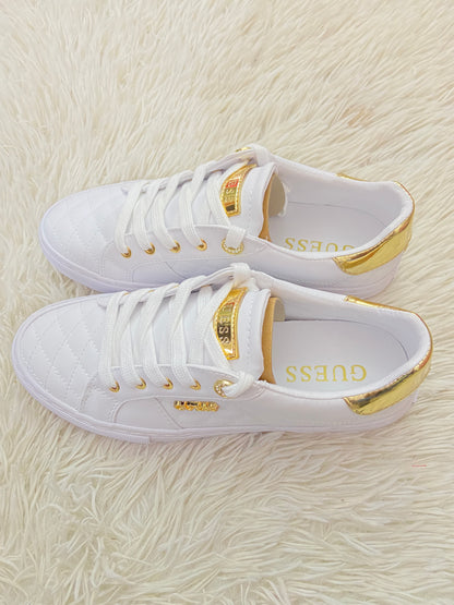 Tenis GUESS original blanco con detalles en color dorado y placa GUESS en dorado.