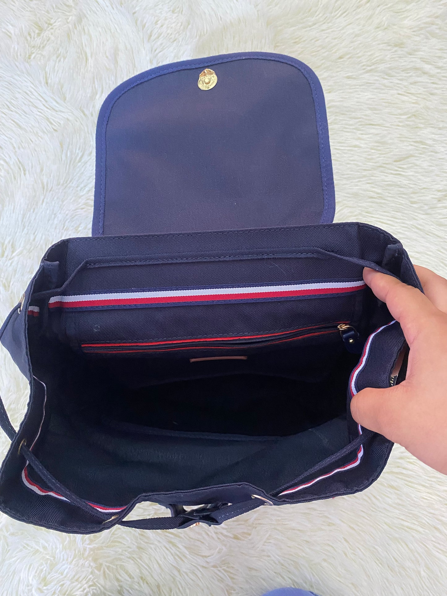 Mochila Tommy Hilfiger original en color azul marino, nombre TOMMY en grande en un bolsillo con el fondo rojo, varios compartimentos, súper espacioso.