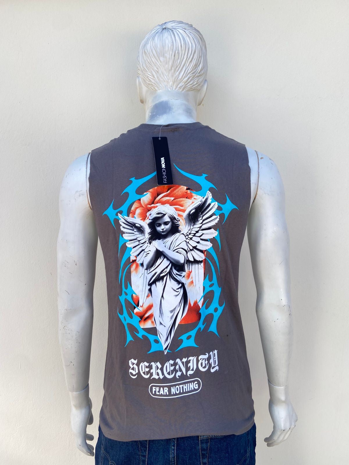 Franela en color gris oscuro con letras blancas diseño azul y estampado de angel atras. serenity fear nothing.