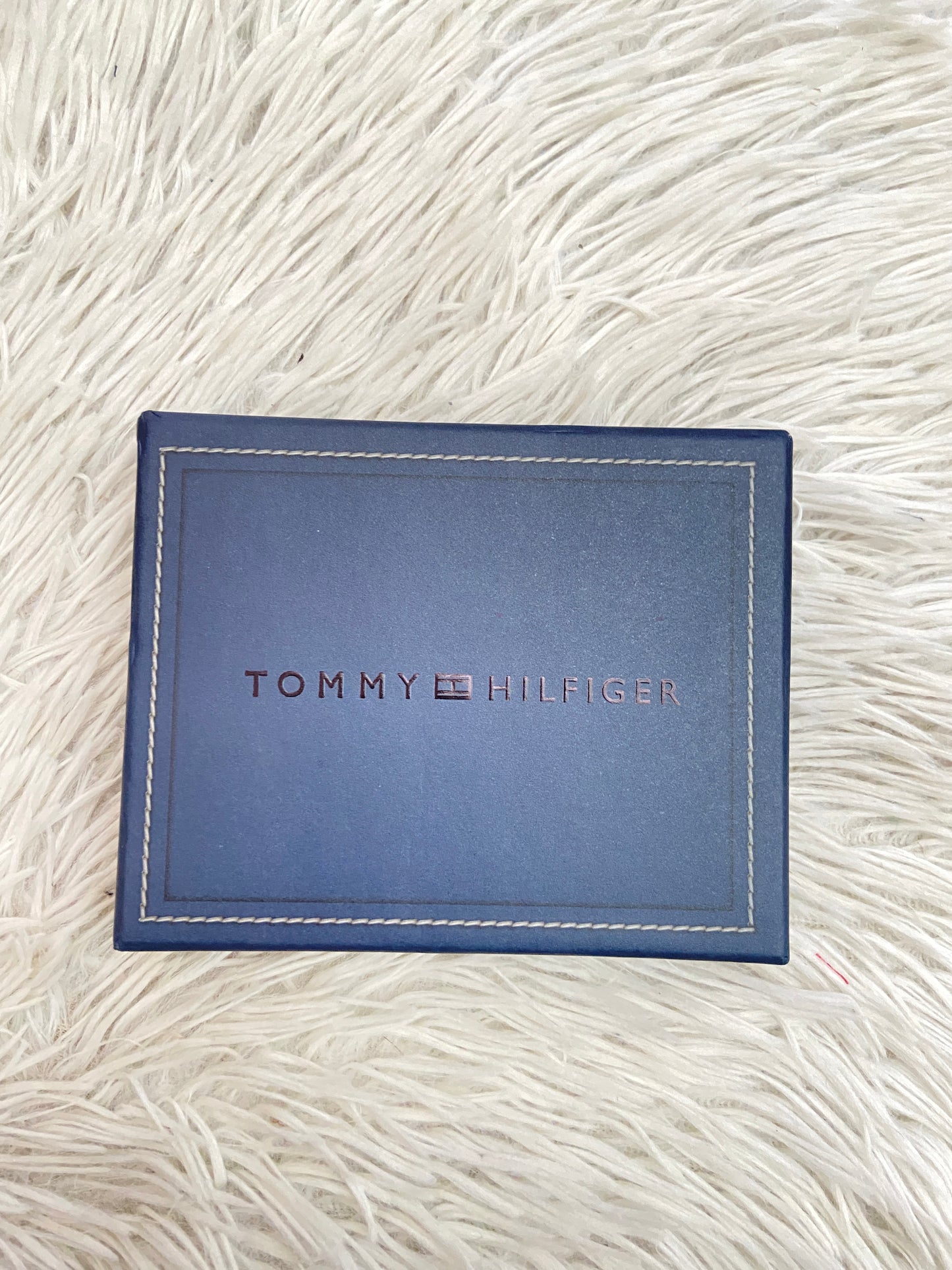 Billetera Tommy Hilfiger original marrón súper oscuro con letras HILFIGER al lado.