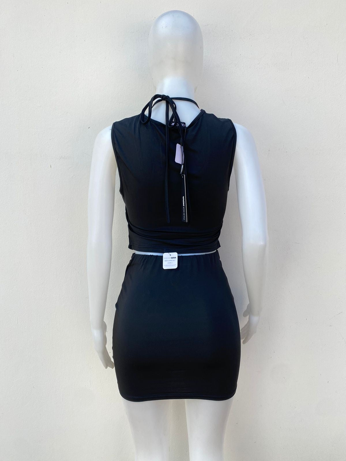 Conjunto Fashion Nova original negro de falda, y abierto en frente.